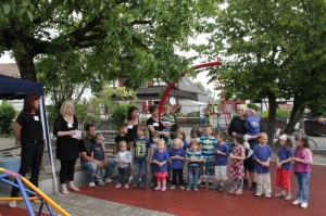 Kinder und Erzieherinnen vor der neuen Schaukel